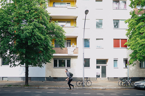 Man skateboarding to the work in the street of Berlin, Germany.