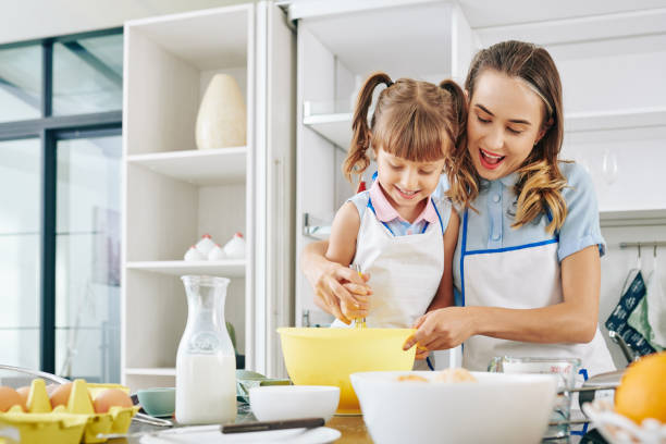 istock Mother and daughter making pancakes 1257134588