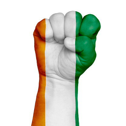 Cote d'Ivoire national flag painted onto a male clenched fist. Strength, Power, Protest concept. Image on a white background. Isolate