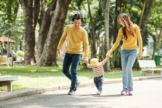 istock Father and mother walking with kid 1257136959