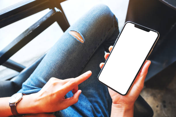 istock a woman holding mobile phone with blank white desktop screen 1257137090