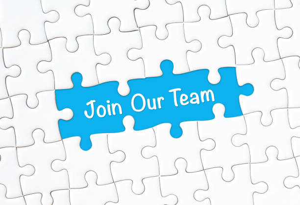istock Join our team concept. White jigsaw puzzle with word and blue background 1257137108