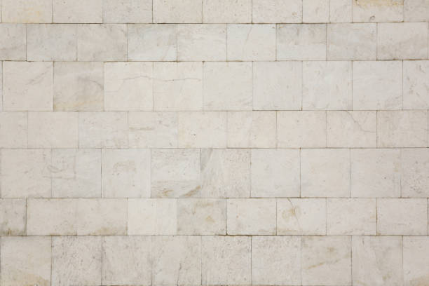 Natural texture and background. Marble tiled wall Natural texture and background. The wall of the house is covered with white marble tiles. stone wall stock pictures, royalty-free photos & images