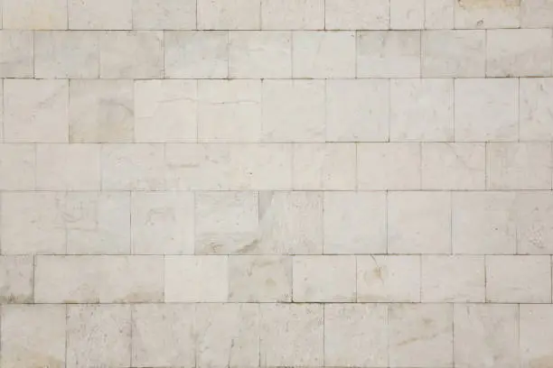 Natural texture and background. The wall of the house is covered with white marble tiles.