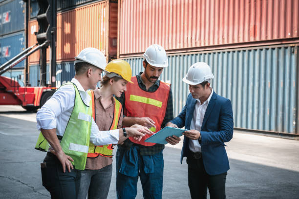 istock Transport Container Shipping Worker Team Meeting Discussion About Freight Control at Cargo Import/Export Logistic Warehouse. Transport Engineers Teamwork Brainstorming Their Containers Ship Project. 1257143670