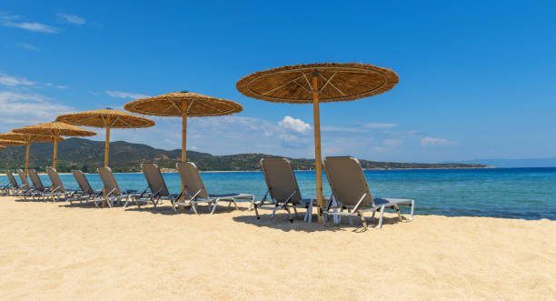 istock Beach chairs with umbrella with blue sky 1257143722