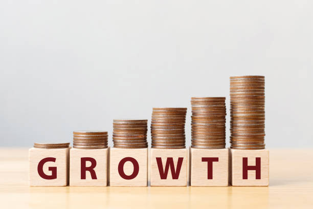 istock Coins on stack stair as step growing growth and wooden cube block with word GROWTH. Investment and save money increase concept 1257143782