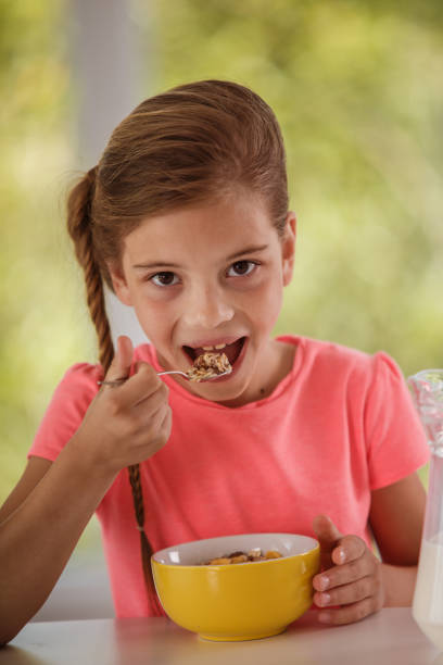 istock Little girl eating cereal with milk for breakfast 1257143848
