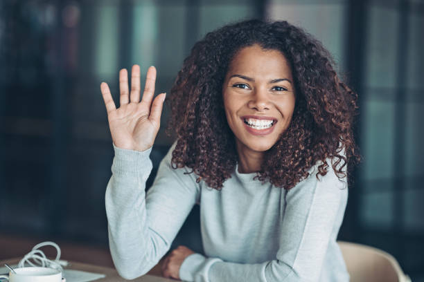 Beautiful young African ethnicity woman Portrait of a smiling young businesswoman waving gesture stock pictures, royalty-free photos & images