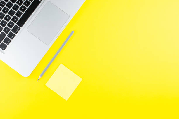 istock Laptop,  note sticks and pencil on yellow background. Flat lay. Copy space. Workplace in the office. 1257156828