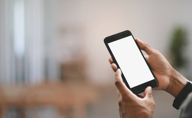istock Cropped image businessman's hands are using a white blank screen smartphone over blurred background. 1257159174