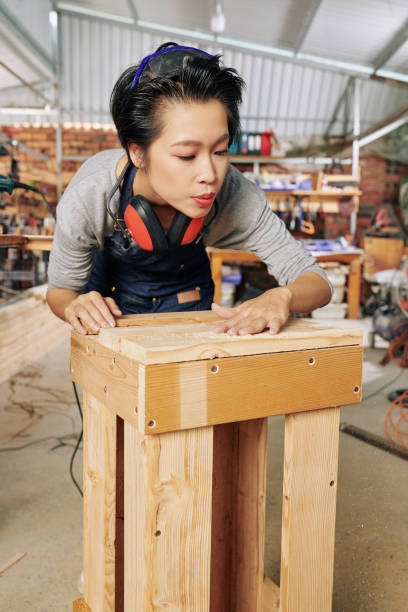 istock Carpenter blowing away wooden shavings 1257159341