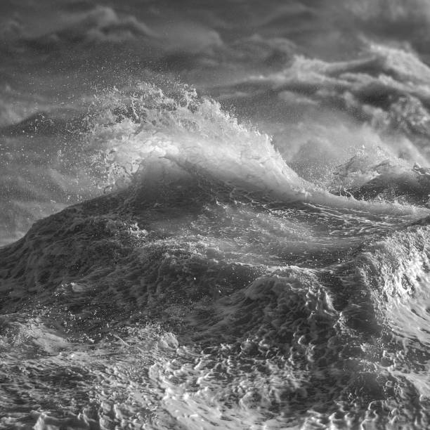 istock Amzing image of individual wave breaking and cresting during violent windy storm in black and white with superb detail 1257163371