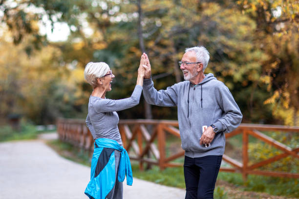 istock Mature couple taking high five with hands afther jogging in public park 1257163422