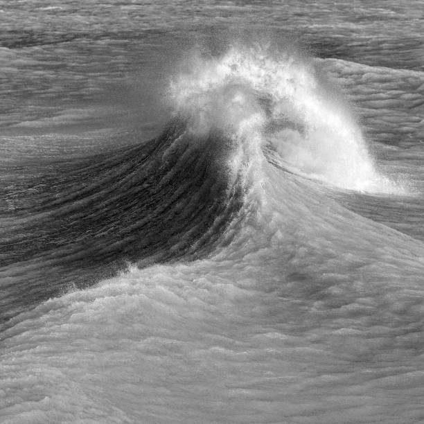 istock Amzing image of individual wave breaking and cresting during violent windy storm in black and white with superb detail 1257163513