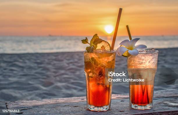 Drinks With Blur Beach And Sunset In Background Stock Photo - Download Image Now - Cocktail, Beach, Drink