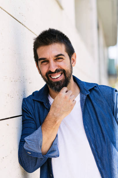 istock Cheerful bearded man with hand on chin while looking camera 1257165166