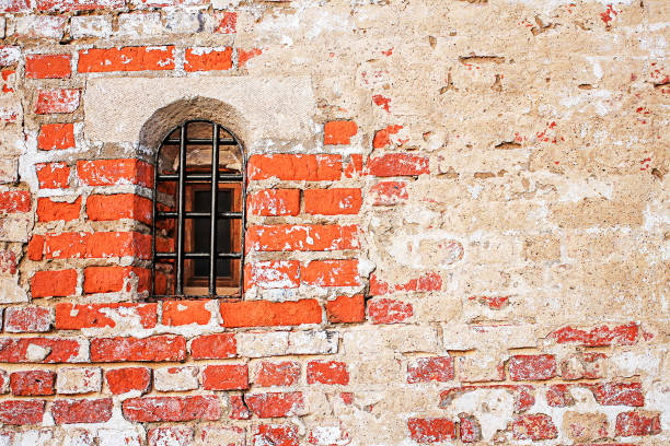 istock A small bow window with a grid on the facade of a brick old building. 1257165845