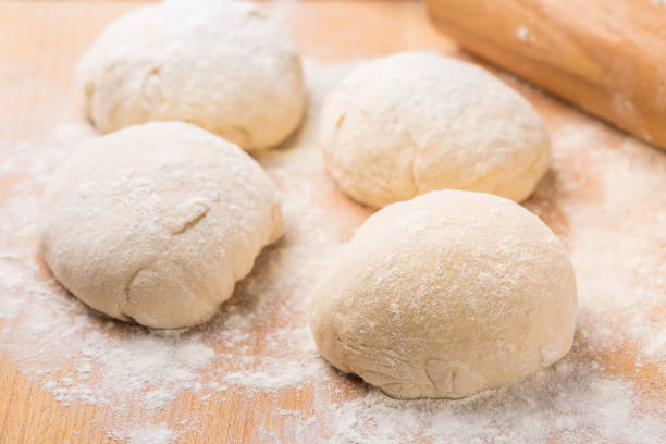 istock Freshly prepared yeast dough for pizza or bread on wooden background. 1257166724