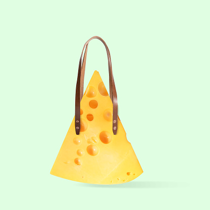 Female bag, shopper made of big piece of cheese on green background. Copyspace to insert your text. Modern design. Contemporary artwork, collage. Concept of inspiration, creativity, artwork.
