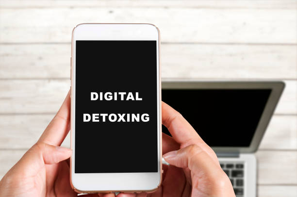 istock Hands holding a mobile phone with Digital Detoxing text on the screen 1257167238