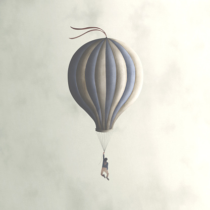 man hanging on a surreal blue balloon flying in the sky