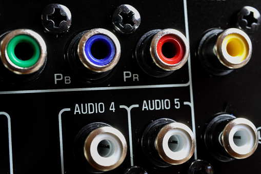 View on isolated cinch sockets of back side of black dolby surround receiver in a row - Germany