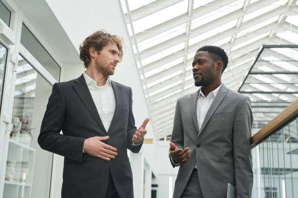 istock Two Modern Businessmen Walking in Office Building 1257170494