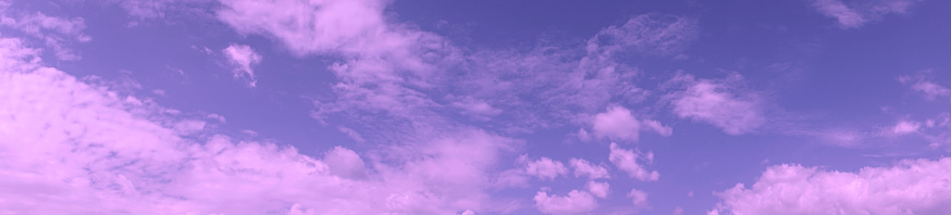 Panoramic view of the sky. Blue sky with pink purple clouds at sunset.