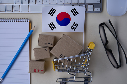 online shopping concept with shopping cart with brown boxes and flag of south Korea