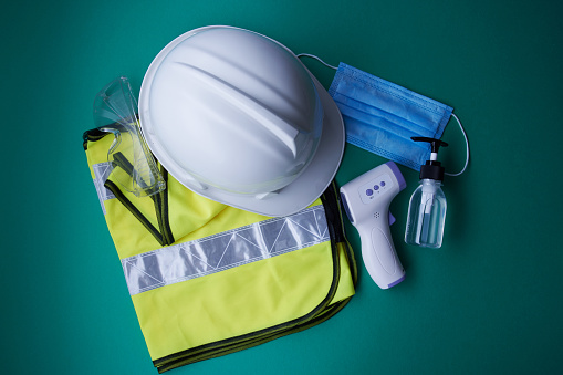new normal of construction worker  safety equipment - helmet,hand sanitizer ,face mask and thermometer