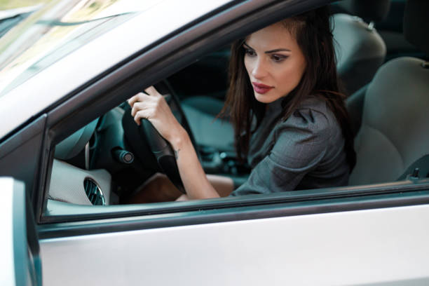 istock Beautiful young woman driving a car 1257171616