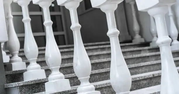 white marble balusters and stone stair case near entry to luxury villa or hotel side view