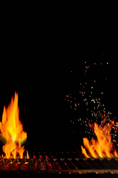 istock Empty hot barbecue BBQ grill with bright burning fire and sparks, smoldering coal on black background. Close up, copy space 1257174763