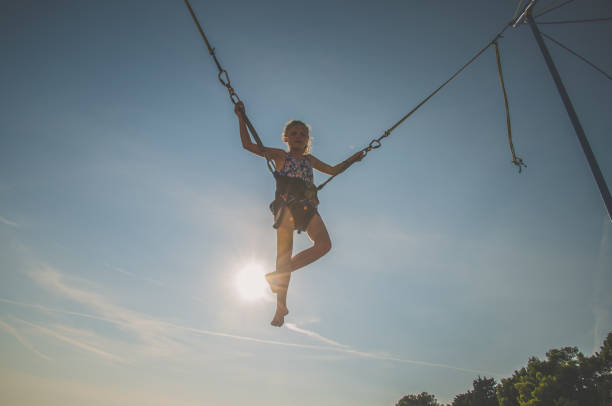 istock active child in bungee jumping trampoline at sunset 1257175034