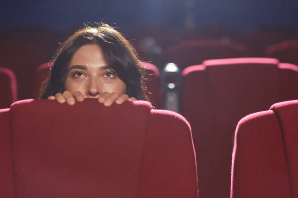 istock Scared Woman Hiding in Cinema 1257175439