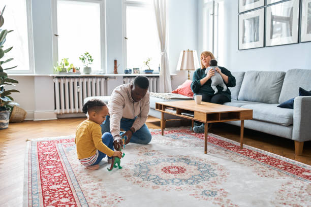 istock Father playing with boy while mother holding son at home 1257177714