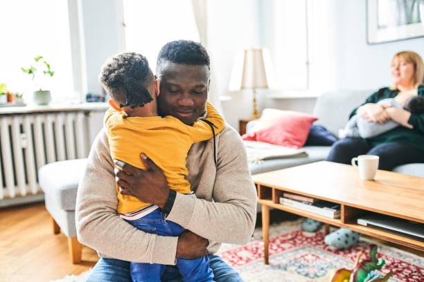 istock Father embracing son at home 1257177781