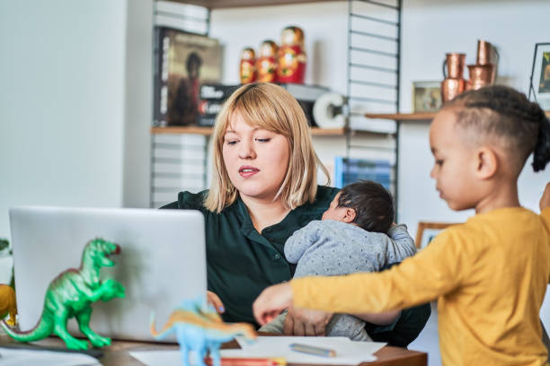 istock Working mother with newborn while son playing at home 1257178073