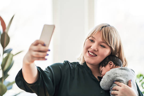 istock Mother taking selfie with sleeping baby at home 1257178125