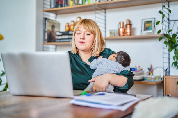 istock Mother working while carrying baby at home 1257178170