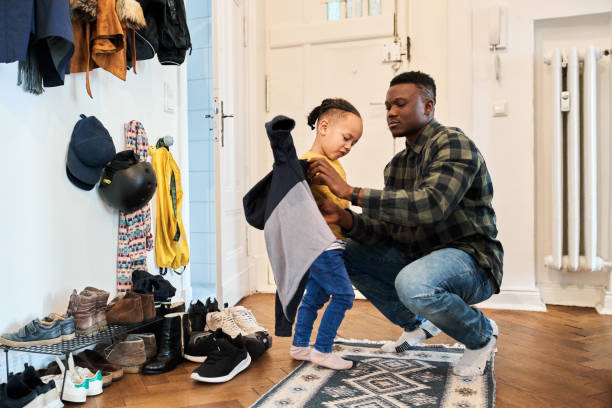 istock Father dressing up son in living room 1257178245