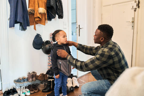 istock Father dressing up boy in living room 1257178252