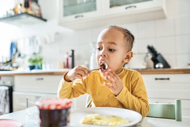 istock Boy eating food at home 1257178306