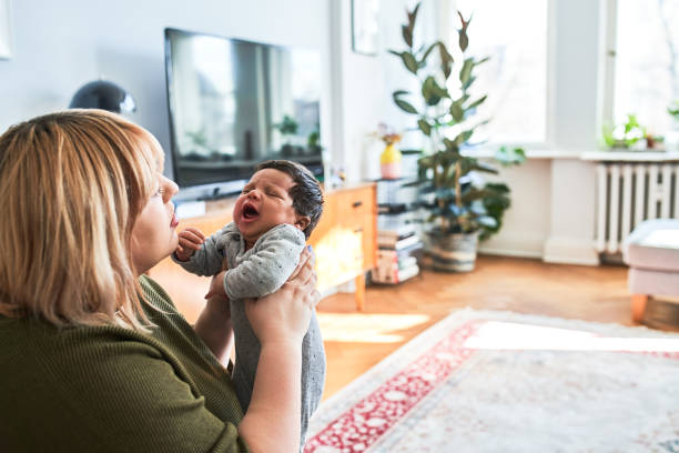 istock Mother holding crying baby at home 1257178325