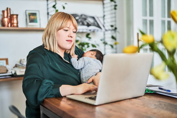 istock Mother working while carrying newborn at home 1257178470
