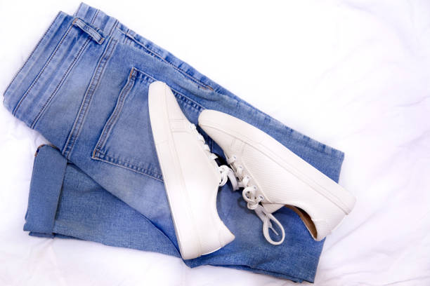 istock Fashionable sneakers and jeans on textile background. 1257180539
