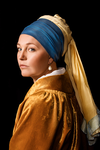 Portrait of a beautiful historical blonde art character wearing a period dress in a studio shot