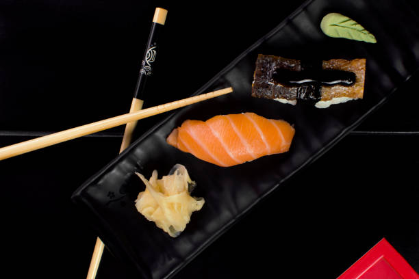 pescado de salmón y piel de salmón niguiri en la mesa del restaurante visto desde arriba - niguiri sushi fotografías e imágenes de stock
