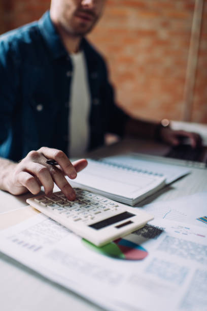istock selective focus of businessman using calculator near notebook 1257184757